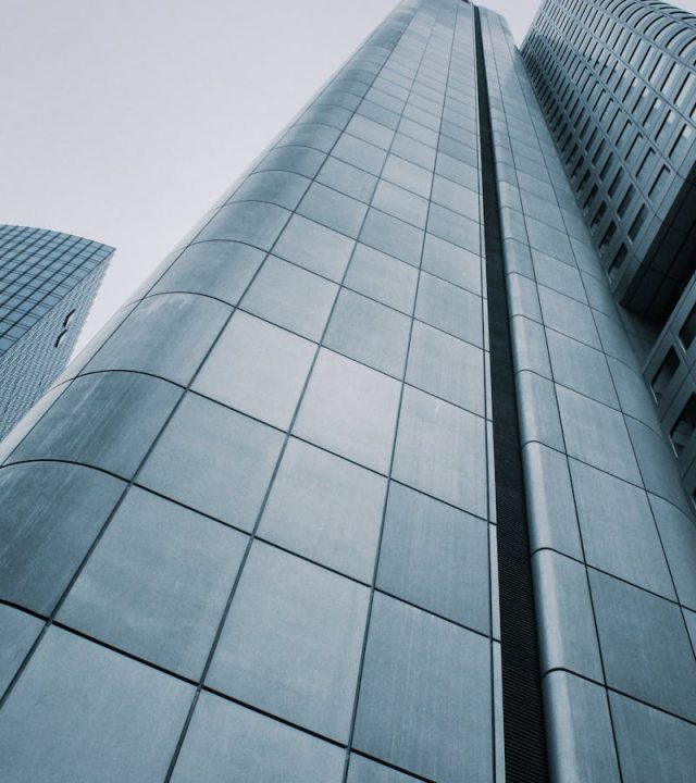Low angle view of modern skyscrapers with glass and steel design. Perfect for corporate imagery.